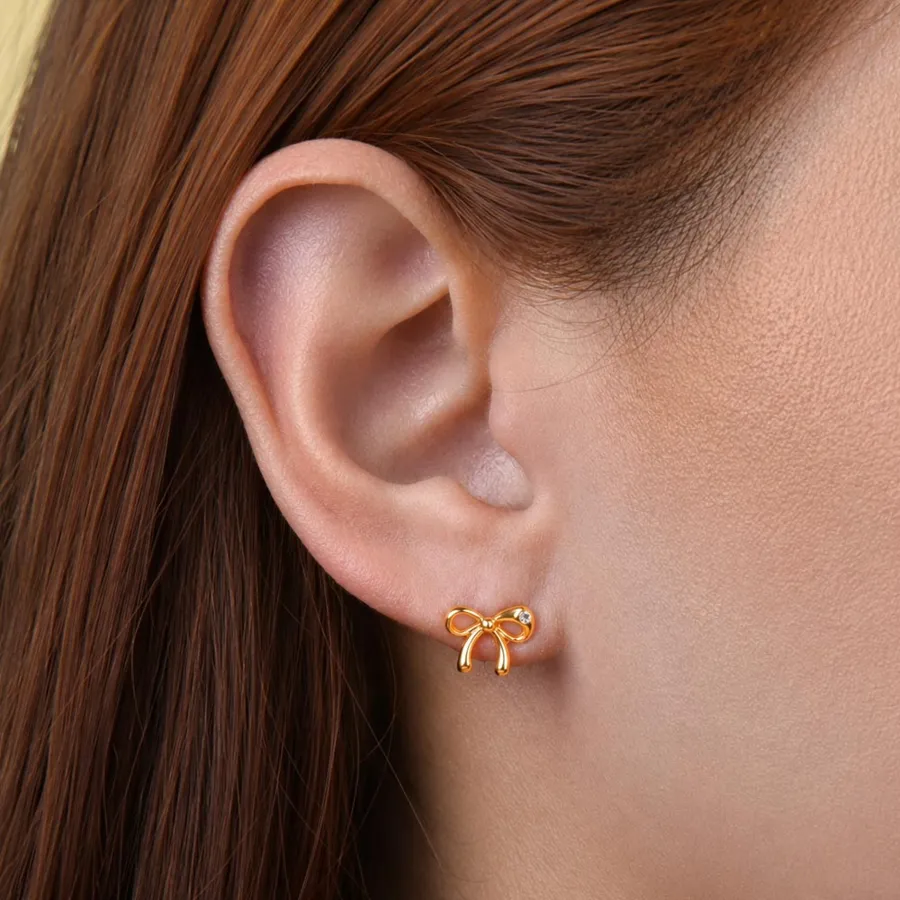 Topos con forma de moño dorado Covergold puestos en la oreja